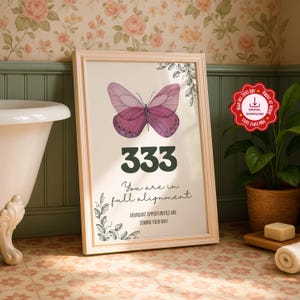 Puede incluir: Un cuadro enmarcado con una mariposa morada y el número 333 en verde oscuro. El texto dice "You are in full alignment" y "Abundant opportunities are coming your way". El marco es de color beige claro.