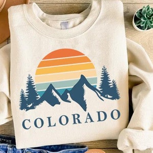 a shirt that says colorado with mountains and trees on it