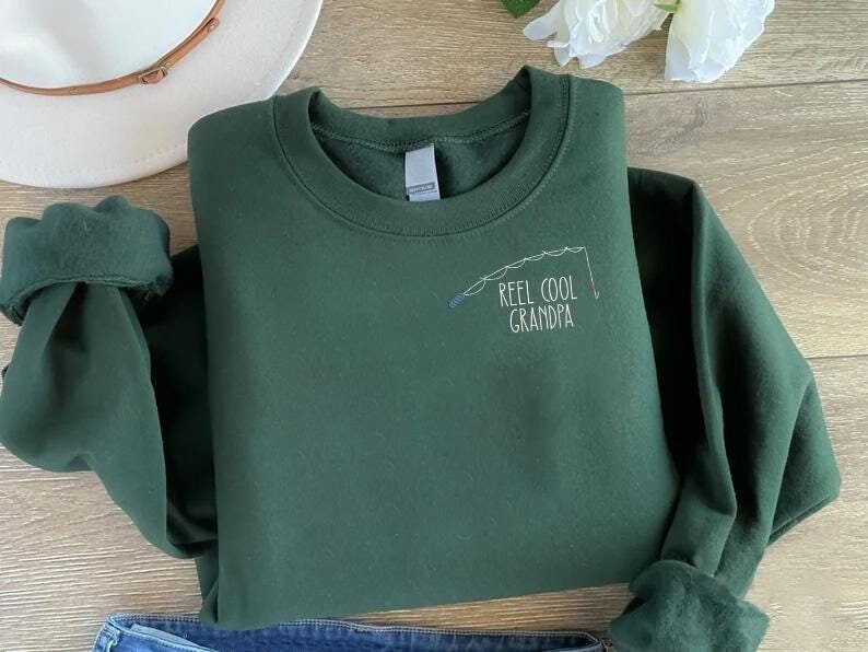 a t - shirt that says reel cool grandpa on it