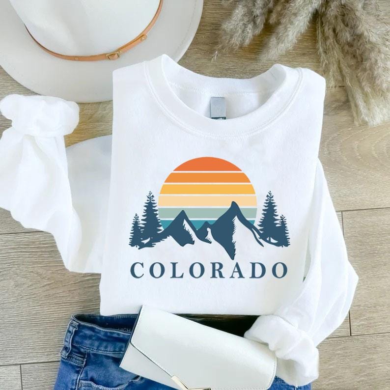 a white shirt that says colorado with mountains and trees on it