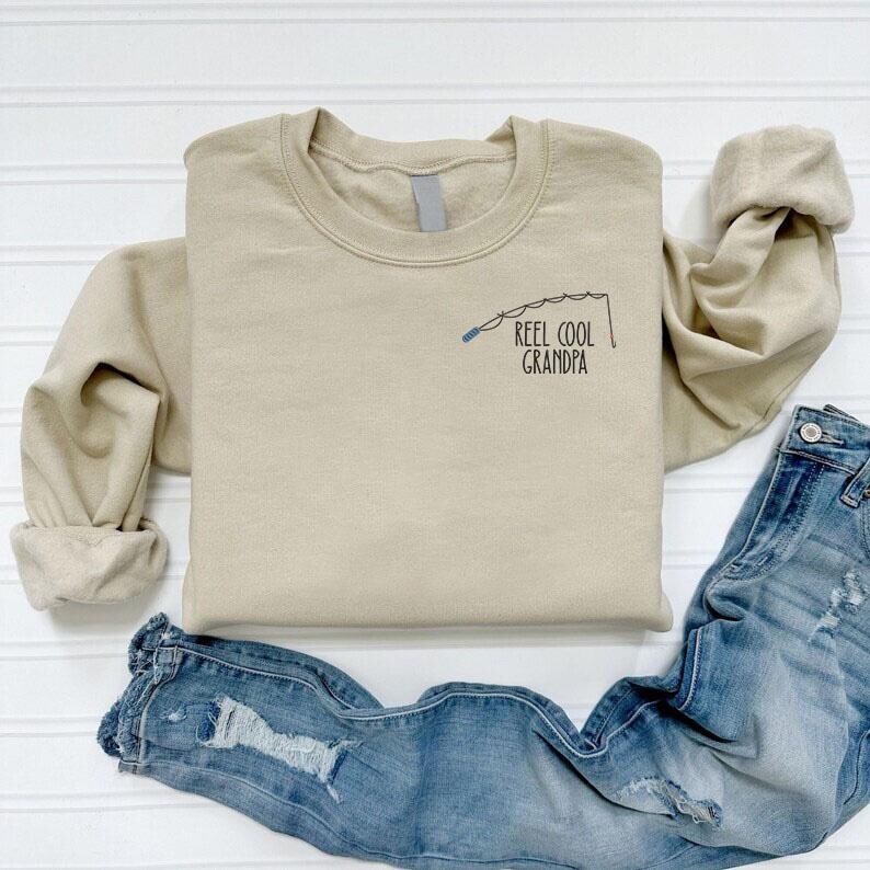 a t - shirt that says reel cool grandpa on it