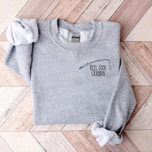 a t - shirt that says reel cool grandpa on it