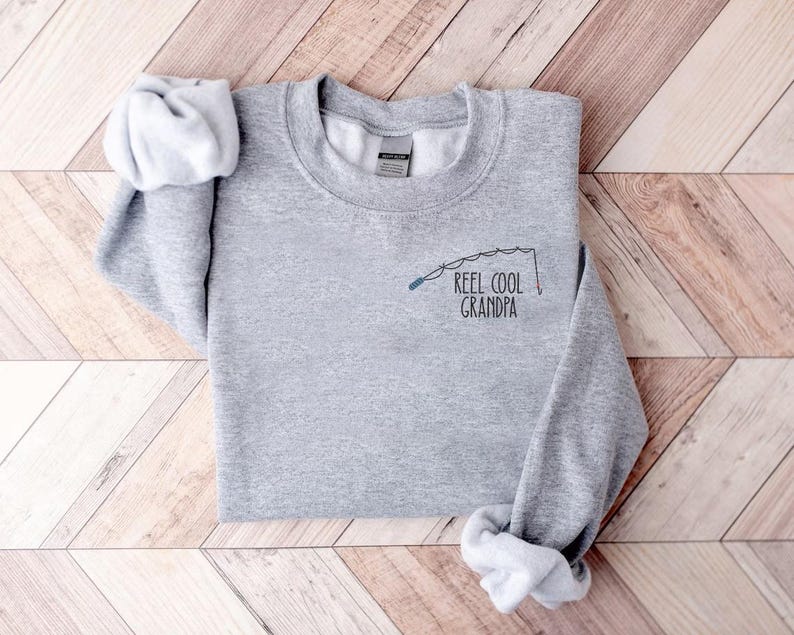 a t - shirt that says reel cool grandpa on it