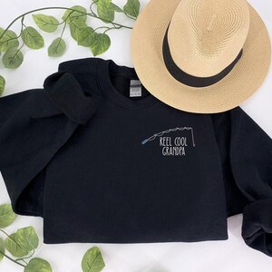 a t - shirt that says reel cool grandpa on it