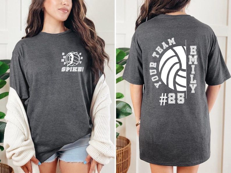 May include: A dark grey t-shirt with a volleyball graphic and the text "Spike!" on the front. The back of the shirt has a volleyball graphic with the text "Your Team" and "Emily #25".