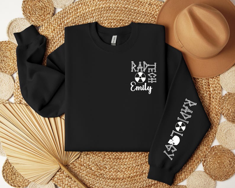 May include: Black sweatshirt with white text that reads "RAD TECH" and "RADIOLOGY" with a skull and crossbones symbol on the sleeves. The text "Emily" is centered on the front of the sweatshirt.