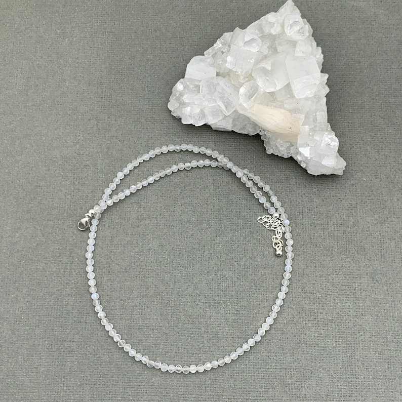 Puede incluir: Un delicado collar de piedra lunar blanca con cierre de plata. El collar est&aacute; hecho de peque&ntilde;as cuentas redondas y mide aproximadamente 45 cm de largo.