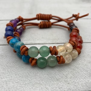 May include: A brown leather bracelet with seven chakra stones. The stones are amethyst, lapis lazuli, blue apatite, green aventurine, citrine, clear quartz, and carnelian.