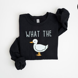 May include: Black sweatshirt with a white duck and the text "What the" printed on the front.