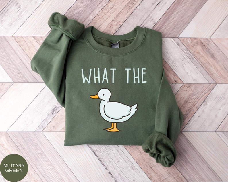 May include: A green sweatshirt with the text "WHAT THE" and a cartoon duck illustration.
