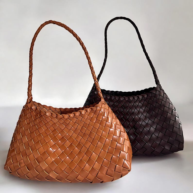 May include: Two woven leather handbags, one brown and one dark brown. The bags have a rectangular shape with a woven pattern and a single top handle.