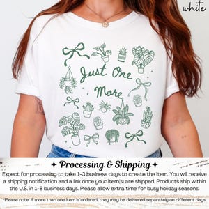 K&ouml;nnte beinhalten: Wei&szlig;es T-Shirt mit einer gr&uuml;nen Illustration von Topfpflanzen, Schleifen und dem Text "Just One More". Das Design zeigt verschiedene Pflanzenarten und dekorative Elemente, ideal f&uuml;r Pflanzenliebhaber.