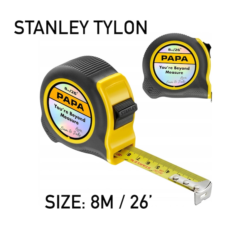 Puede incluir: Un flex&oacute;metro Stanley Tylon negro y amarillo con el texto "PAPA You're Beyond Measure Love Sam & Jake". El flex&oacute;metro mide 8 metros (26 pies). El texto "STANLEY TYLON" est&aacute; en la parte superior.