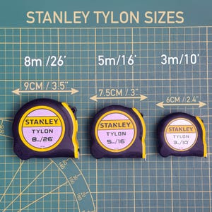 Puede incluir: Tres cintas m&eacute;tricas Stanley Tylon en negro y amarillo, con medidas de 8m, 5m y 3m. La imagen incluye el texto "STANLEY TYLON SIZES" y comparaciones de tama&ntilde;o en cm y pulgadas.