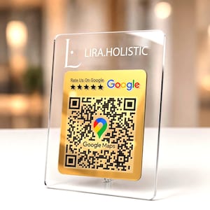 Könnte beinhalten: Ein durchsichtiges Acrylschild mit einem goldfarbenen quadratischen Einsatz, der den Text LIRA.HOLISTIC, Rate Us On Google und Google Maps enthält. In der Mitte befindet sich ein schwarz-weißer QR-Code mit einem bunten Google Maps-Pin.