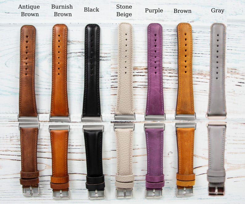 May include: A collection of leather watch bands in various colors, including Antique Brown, Burnish Brown, Black, Stone Beige, Purple, Brown, and Gray. Each band has a silver-tone buckle and is displayed on a light wood surface.