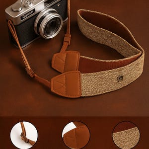 Puede incluir: Una cámara de estilo vintage con una correa de cuero marrón y una sección de nailon tejido. La correa presenta una hebilla rectangular simple y material de cuero de alta calidad. La cámara es plateada y negra, con la marca "Gawon".