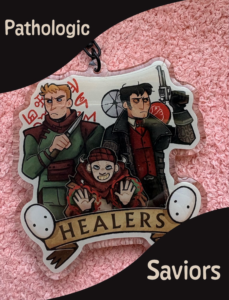 May include: A clear acrylic keychain featuring three illustrated characters from Pathologic. One holds a knife, another a revolver, and a third figure is centered below. The design includes red symbols, a banner with the text HEALERS, and two white masks.