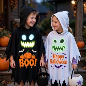 May include: A black hooded poncho with a glowing green ghost face, orange pumpkins, and the text BOO! alongside a white hooded poncho with a glowing green ghost face, purple bats, and the text Happy Halloween, both featuring jagged hemlines.