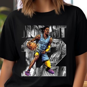 May include: Black t-shirt featuring a stylized illustration of a basketball player in a blue and yellow uniform, holding a basketball. The design includes the name "Ja Morant" and the number "12".
