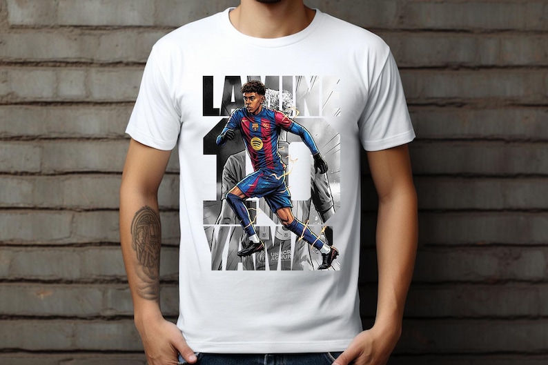 May include: White t-shirt featuring a graphic of a soccer player in a blue and red uniform, with the name "Lamine" and the number "10" in black. The design has a grayscale background.