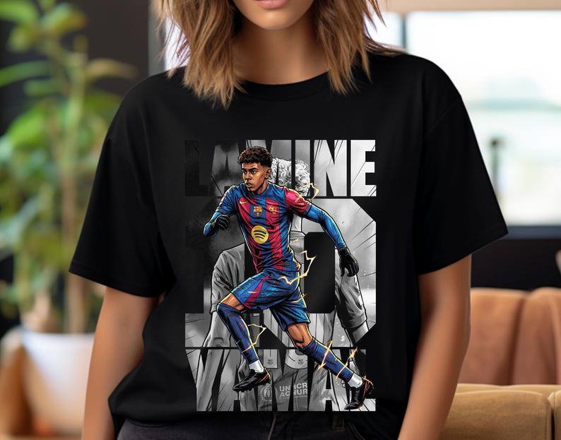 May include: Black t-shirt featuring a graphic of a soccer player in a blue and red uniform, with the name "LAMINE" in white block letters. The design includes a Spotify logo and the number 3. The shirt has a crew neck.