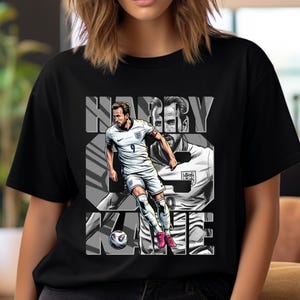 May include: Black t-shirt featuring a graphic of soccer player Harry Kane in a white uniform with the number 9. The name "HARRY KANE" is printed in large, gray block letters. A soccer ball is at the bottom of the graphic.