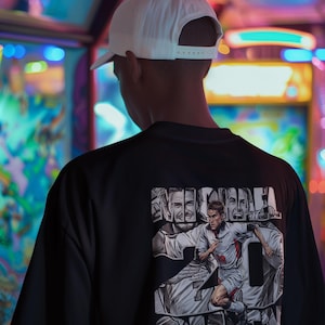 May include: Black t-shirt featuring a graphic of a soccer player with the name "OWEN" and the number 20. The design includes the text "ENGLAND FRANCE 1998". A white baseball cap is worn.