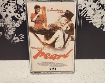 May include: A vintage cassette tape case with a photo of a woman in a red dress and a man in a hat. The text on the case reads "The gulf is... pearl".