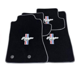 May include: Set of four black car floor mats with gray trim and a white embroidered Mustang logo with red and blue stripes.