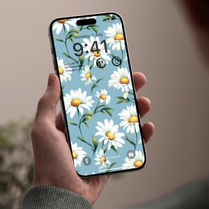 May include: A smartphone displays a floral wallpaper featuring white daisies with yellow centers and green leaves on a light blue background. The screen shows the date and time: Monday, July 1, 9:41.