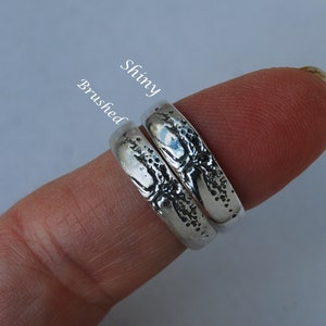 K&ouml;nnte beinhalten: Zwei silberne Ringe mit einem strukturierten Design. Ein Ring hat eine gl&auml;nzende Oberfl&auml;che, w&auml;hrend der andere eine geb&uuml;rstete Oberfl&auml;che hat. Die Ringe sind mit "Shiny" und "Brushed" beschriftet.