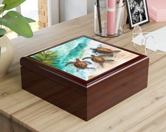 Puede incluir: Una caja de madera marrón oscuro con una tapa decorativa que presenta una escena de playa con tres tortugas marinas. Las tortugas son marrones y tostadas, y el agua es turquesa. La caja está sobre una superficie de madera marrón claro.