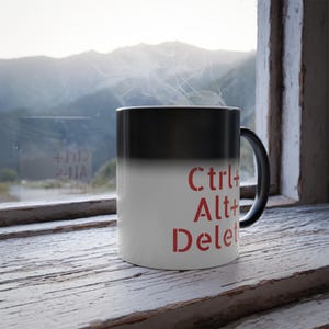 May include: A black and white color-changing mug with the text "Ctrl+Alt+Delete" in red.