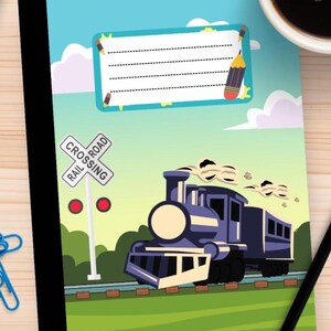 Può includere: Quaderno blu con un disegno di un treno dei cartoni animati, un segnale di passaggio a livello e un'etichetta per il nome del proprietario. Il treno è blu scuro con dettagli bianchi, su uno sfondo verde e blu. Una matita e una tazza di caffè sono sulla superficie di legno.
