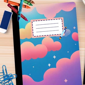 May include: A notebook with a sky-themed design, featuring pink and purple clouds on a blue backdrop. It has a label for writing. Crayons, an eraser, and paper clips are placed around the notebook on a wooden surface.