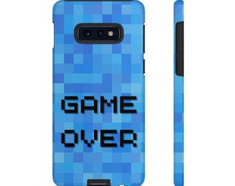 May include: A blue pixelated phone case with the words "GAME OVER" in black block letters. The case has a black camera and flash area. The case is shown from the front and side.