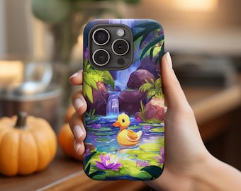 May include: A phone case featuring a vibrant illustration of a yellow rubber duck in a pond with a waterfall backdrop. The design includes purple water lilies and lush green foliage, creating a whimsical scene. The case has a dark blue border and the name "Helena" is written on the bottom.
