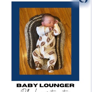 Könnte beinhalten: Ein Neugeborenes in einem weißen Strampler mit braunen Football-Grafiken, das auf einer handgefertigten, grau-braunen Baby-Liege liegt. Die Liege befindet sich auf einem Holzboden. Der Text "Baby Lounger" steht unten.