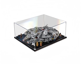 Puede incluir: Una vitrina de acrílico transparente con una base negra, que muestra un modelo LEGO detallado del Halcón Milenario. El modelo incluye varias minifiguras, entre ellas Han Solo, Chewbacca y R2-D2.