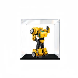 May include: A yellow and black LEGO® Transformers Bumblebee figure in a clear acrylic display case with a black base.