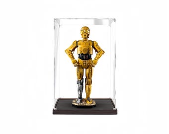 Puede incluir: Una figura dorada de C-3PO de Star Wars, exhibida en una vitrina de acrílico transparente. La figura tiene una pierna plateada y posa con las manos en las caderas. La base es de color marrón oscuro.