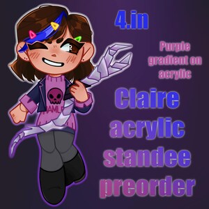 Könnte beinhalten: Cartoon-Illustration einer Figur, die einen silbernen Gegenstand hält. Die Figur trägt einen rosa Pullover mit Totenkopf-Design und eine blaue Jacke. Der Text auf dem Bild lautet "4.in", "Claire acrylic standee preorder" und "Purple gradient on acrylic".