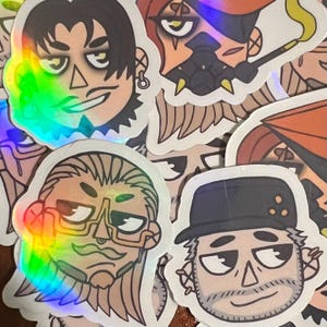 May include: A collection of holographic stickers featuring stylized illustrations of various characters. The stickers have a white border and a shiny, rainbow-like effect. The characters have different facial expressions and hairstyles.