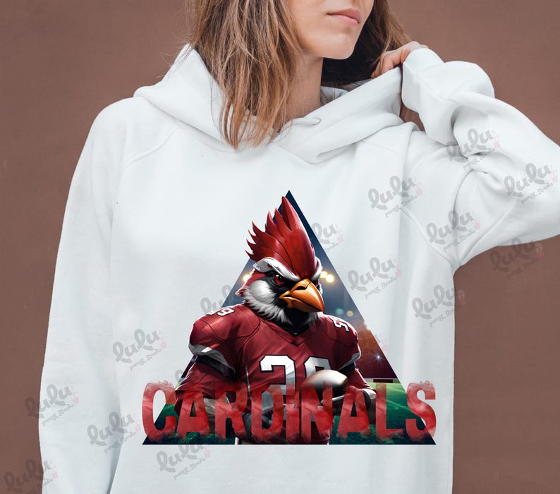 Pu&ograve; includere: Felpa bianca con un mascotte di cardinale rosso che indossa una maglia da calcio con la scritta "CARDINALS" stampata sul davanti. Il mascotte tiene un pallone da calcio.