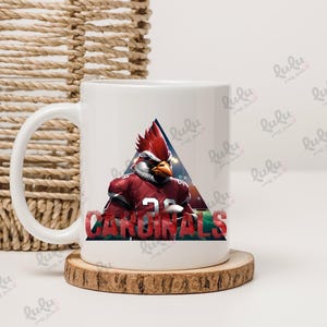 Pu&ograve; includere: Tazza da caff&egrave; in ceramica bianca con un design rosso, bianco e blu con un cardinale dei cartoni animati che indossa una divisa da football. Il testo "CARDINALS" &egrave; stampato sulla tazza.