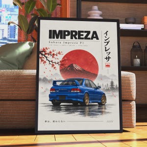 Op de afbeelding: Een ingelijste poster met een blauwe Subaru Impreza P1 van achteren, tegen een achtergrond van een grote rode zon, de berg Fuji en een kersenbloesemtak. De tekst luidt IMPREZA, Subaru Impreza P1, 2.0L Turbo, AWD, 280 PS, 1996-2000 en Japanse karakters.