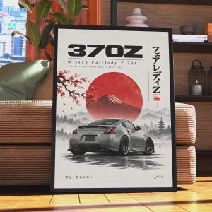 Puede incluir: Un póster enmarcado que muestra un coche Nissan 370Z Fairlady Z Z34 plateado. El diseño incluye un gran sol rojo, el monte Fuji, ramas de cerezo y texto en japonés. El texto dice 370Z, Nissan Fairlady Z Z34, 3.7L V6, Rear-Wheel Drive, 2009-2020 y 夢は、終わらない.