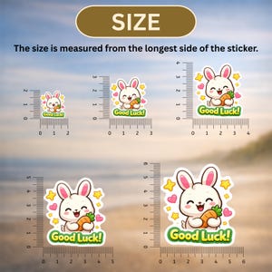 May include: A selection of white bunny stickers holding carrots, with the text "Good Luck!" and surrounded by stars and hearts. The stickers vary in size, with measurements in centimetres.
