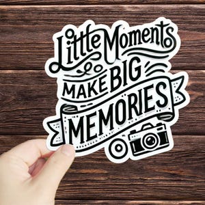 May include: Black and white sticker with the text "Little Moments Make Big Memories" and a stylized camera illustration.